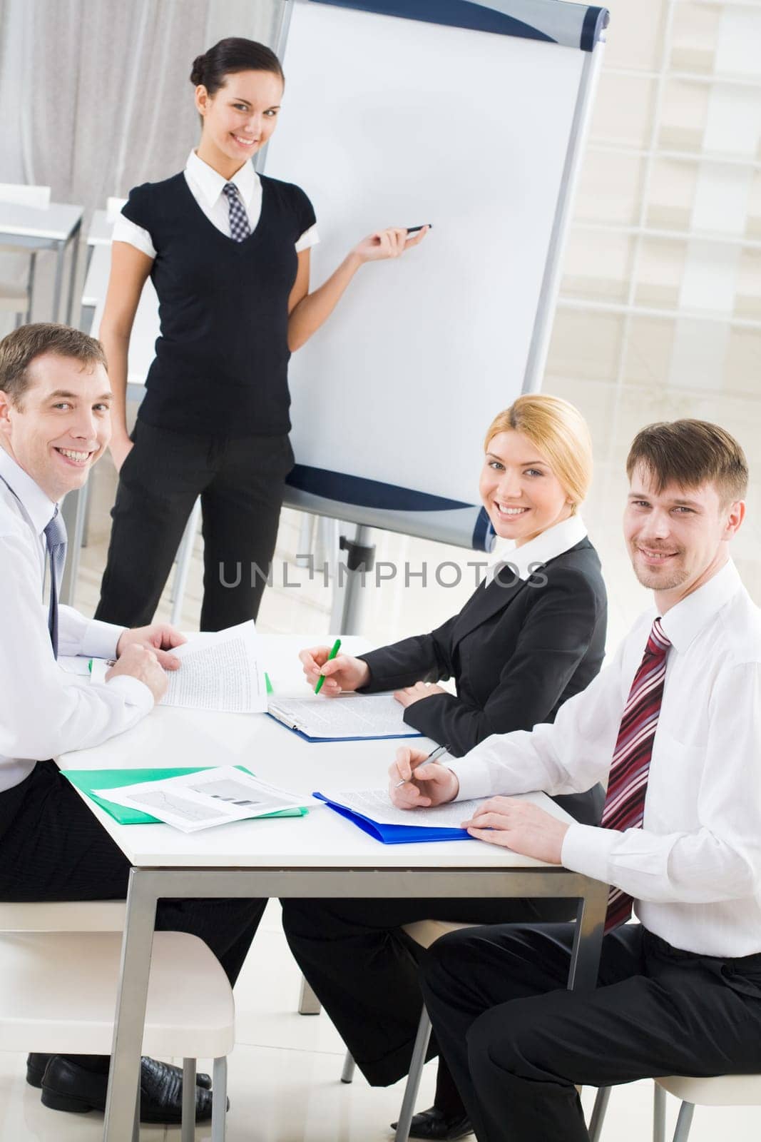 Portrait of smiling business partners looking at camera during meeting in office
