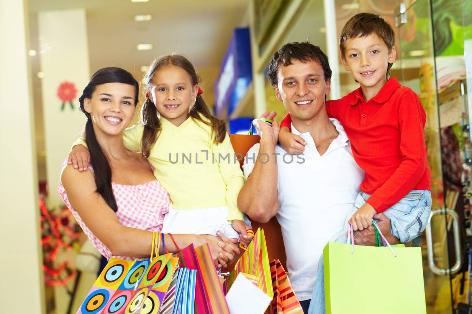 Portrait of happy parents and children with paperbags after shopping