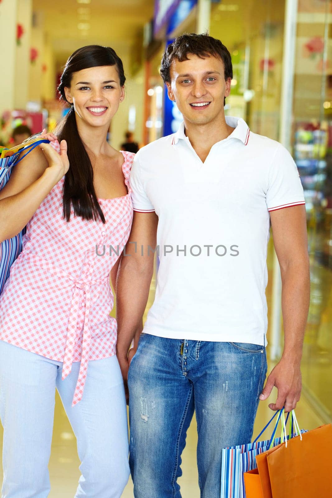 Portrait of happy couple with paperbags during shopping
