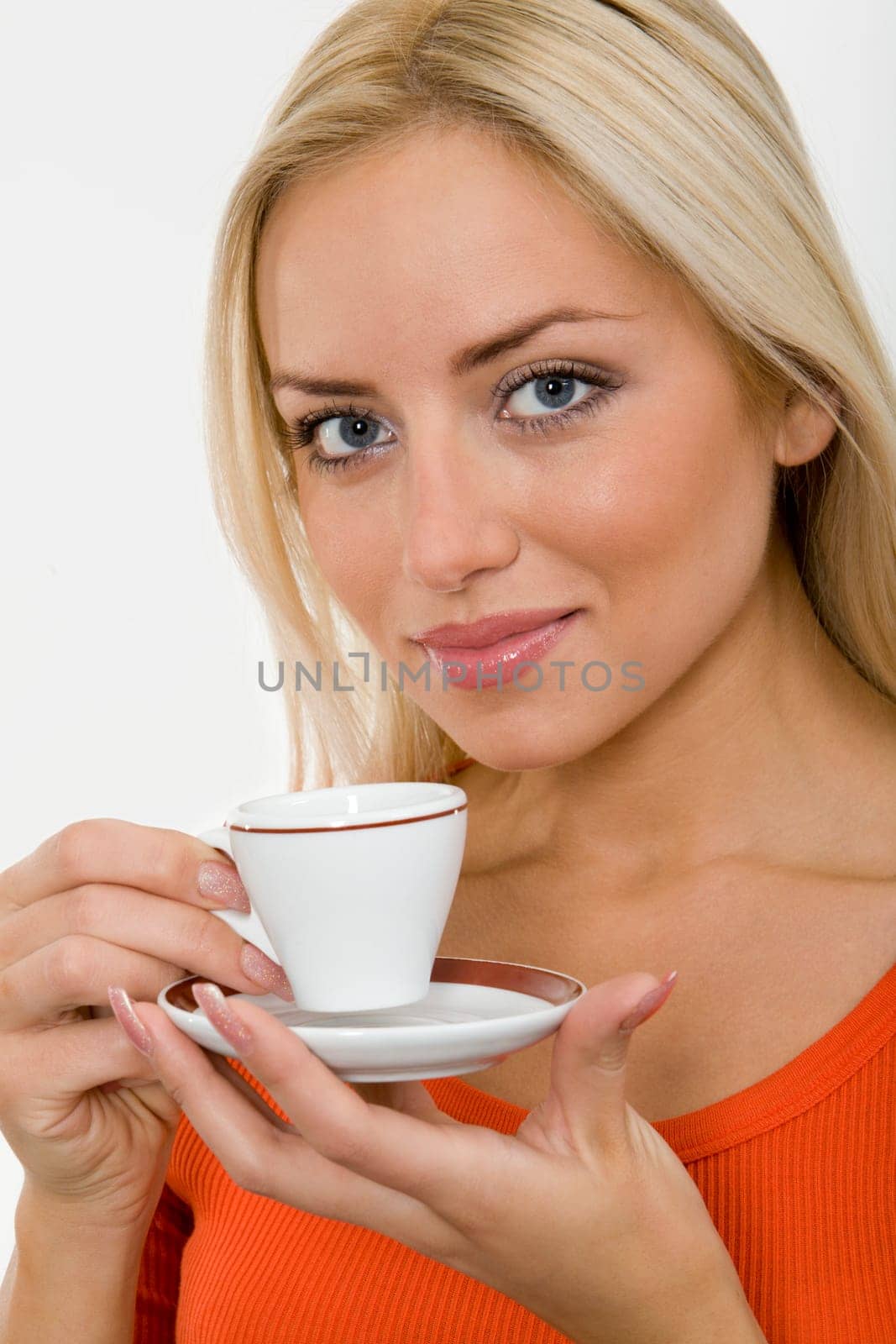 The portrait of young blonde woman with a cup of coffee in her hands