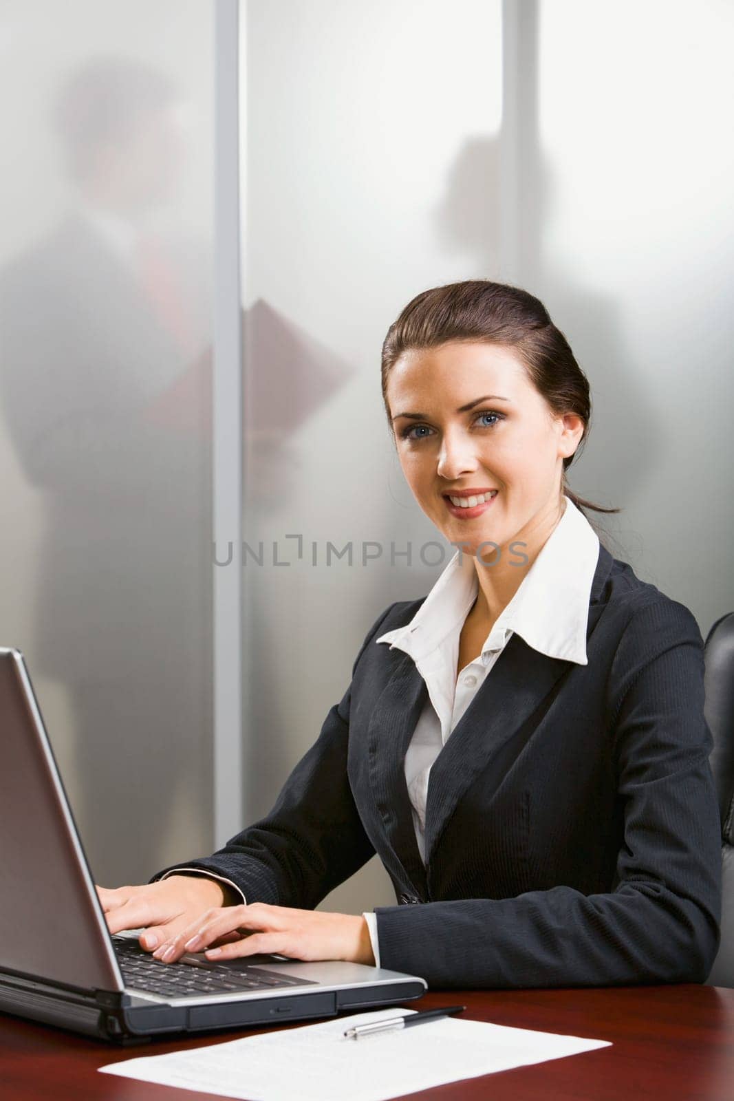 Outstanding smiling specialist is typing on the laptop in the office
