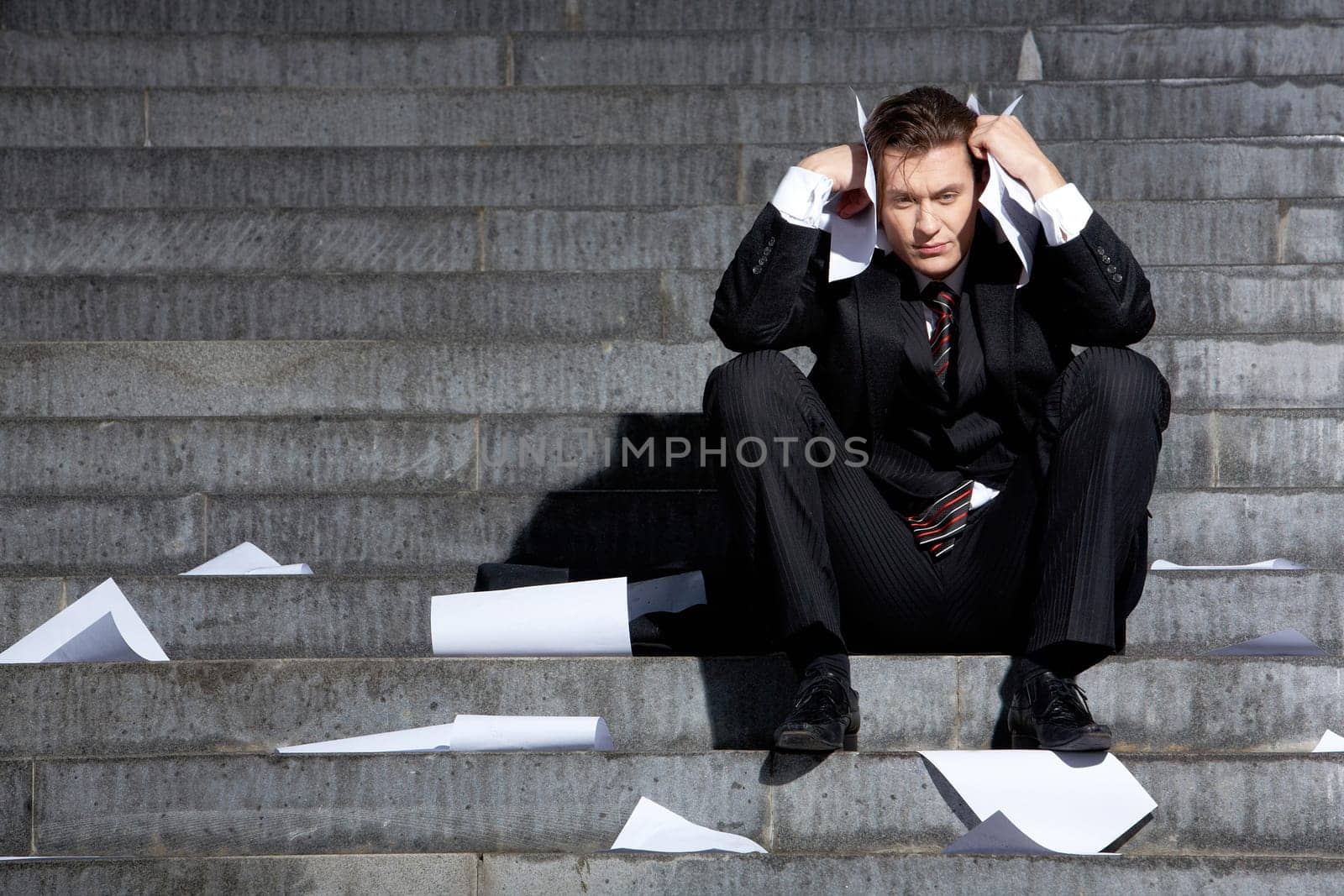 Portrait of unhappy businessman under depression touching his head in grief