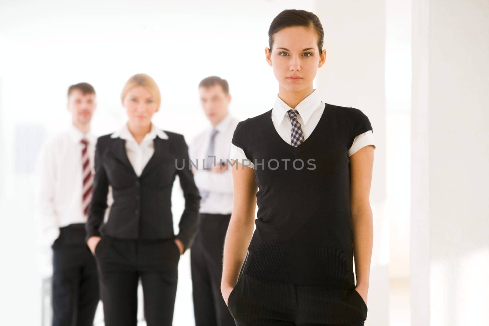 Portrait of attractive business lady looking at camera on background of employees