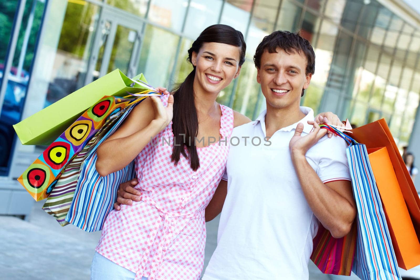 Portrait of happy couple with paperbags after shopping