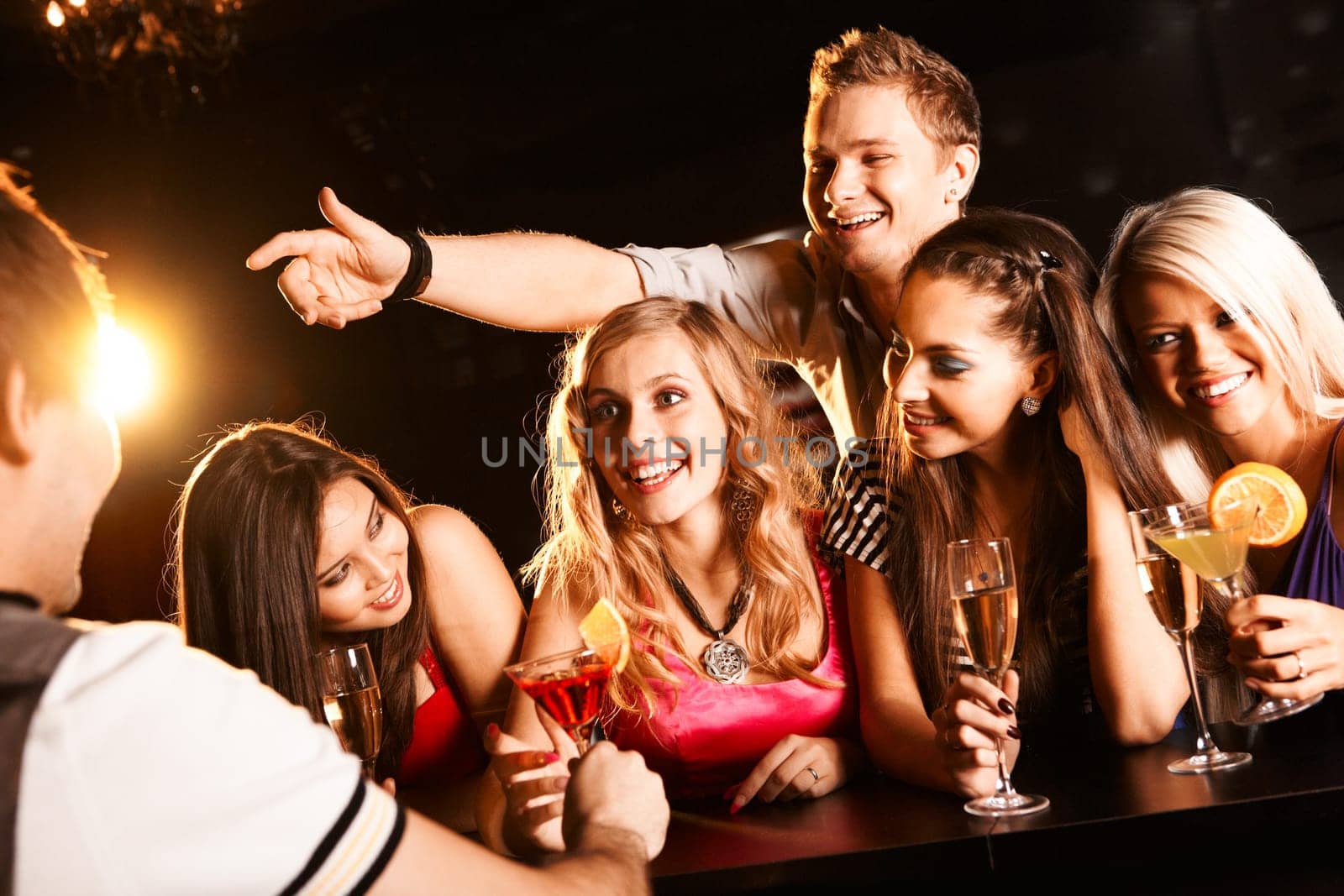 Photo of joyful friends in the bar communicating with barman