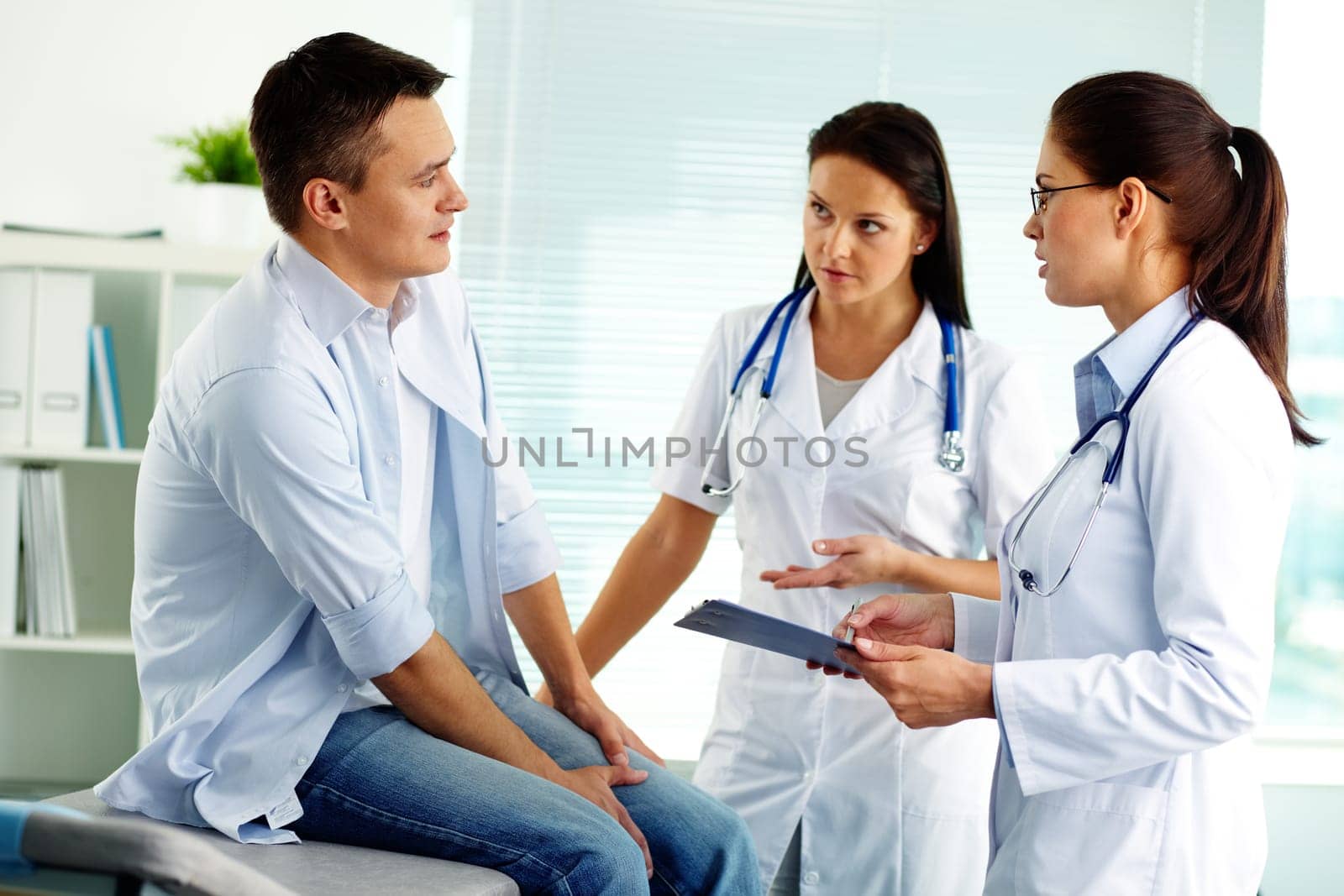 Portrait of confident female doctors consulting patient in hospital