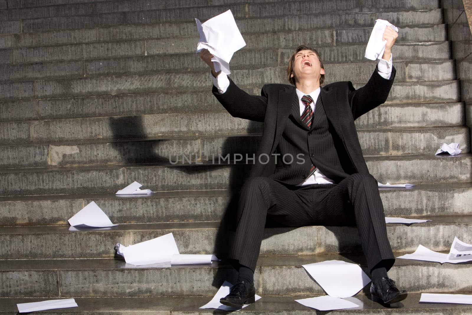 Desperated professional raising his arms upwards and crying during recession