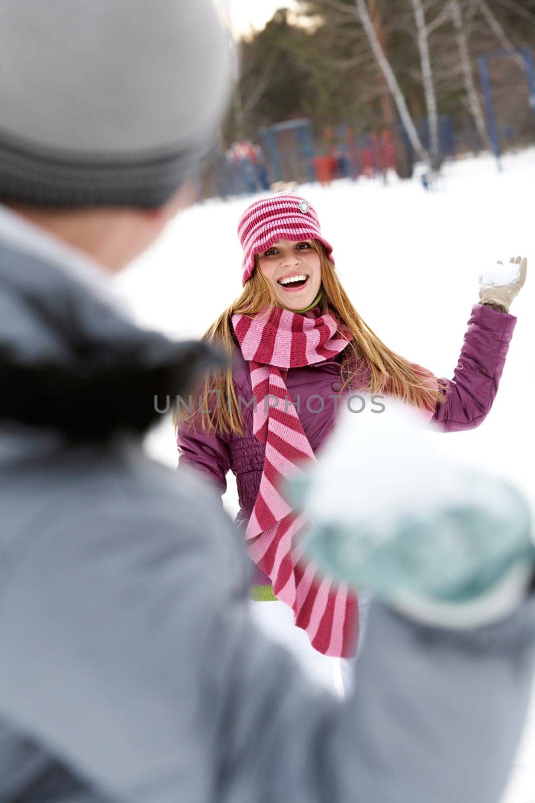 Image of attractive young woman flinging the snowball