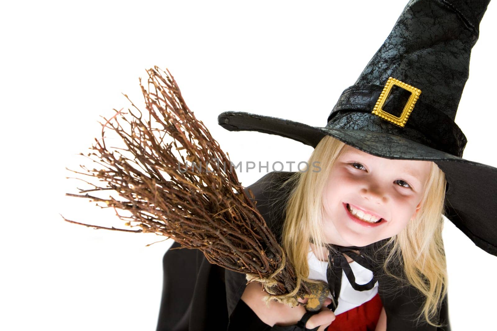 Portrait of girl in halloween costume and broom smilling at camera