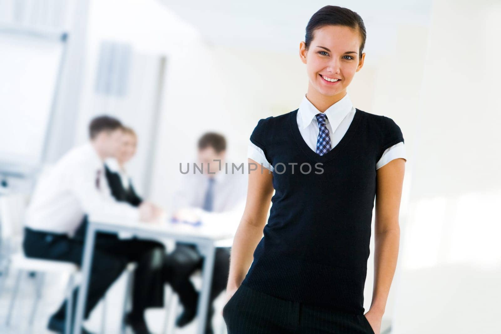 Portrait of young employer with communicating workgroup at background