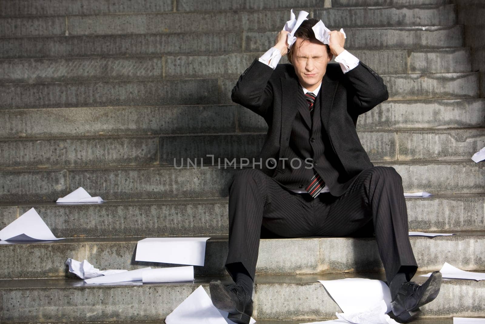 Image of frustrated professional with his eyes closed in grief during crisis