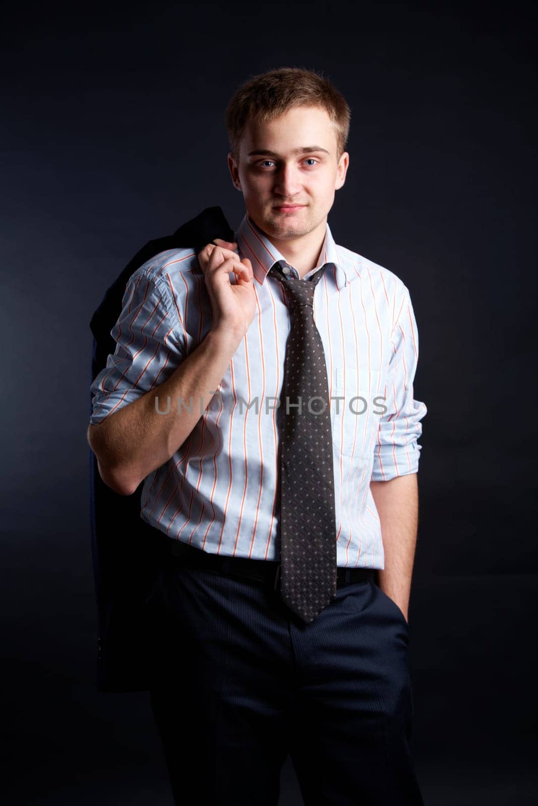 Portrait of stylish businessman looking at camera from darkness