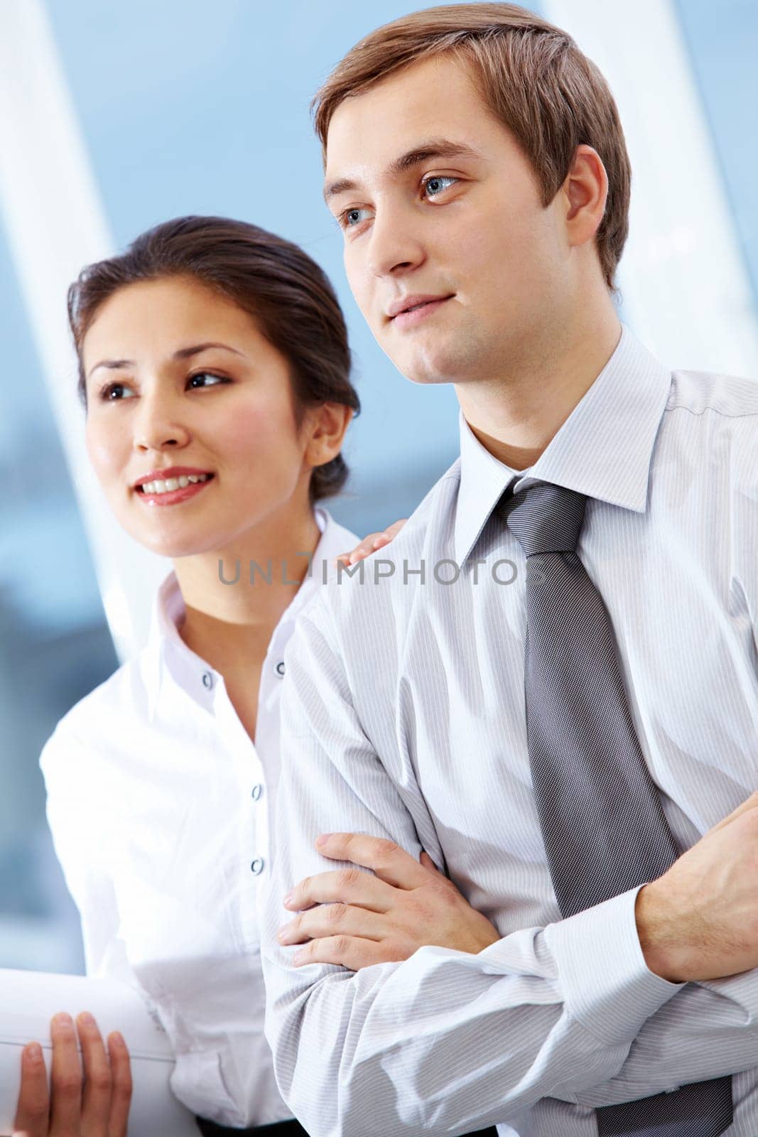 Portrait of successful colleagues looking aside with smiles