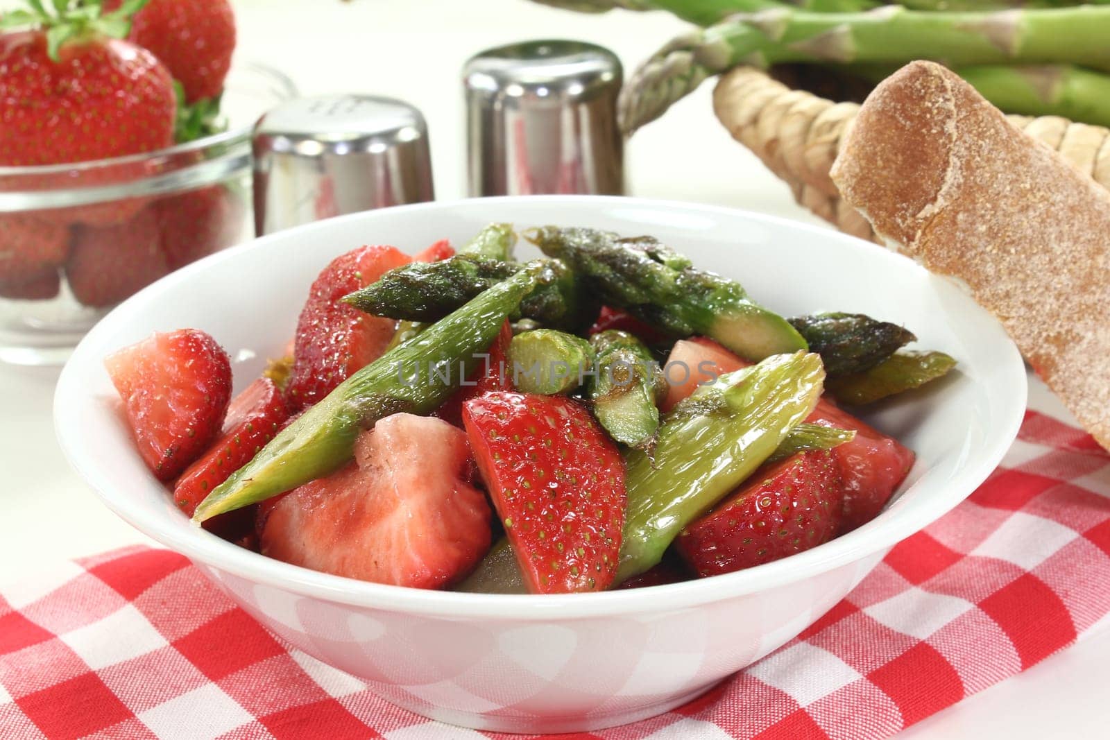 a bowl of asparagus and strawberry salad with fried green asparagus