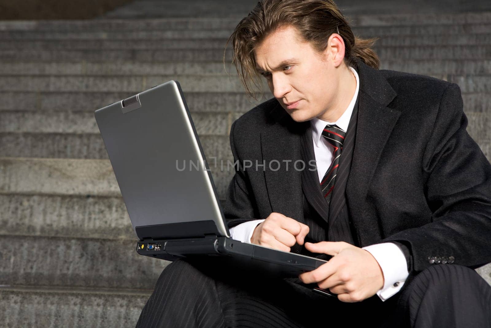 Portrait of serious business leader with laptop looking at its monitor