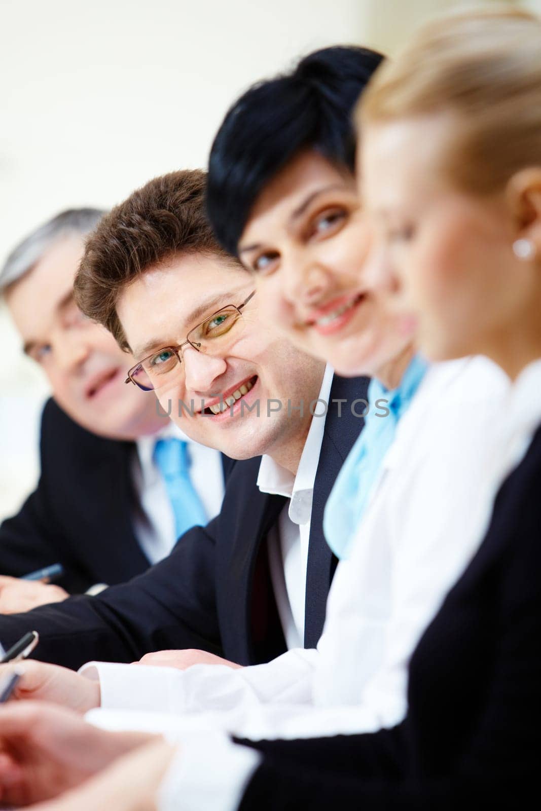 Confident businessman looking at camera among colleagues