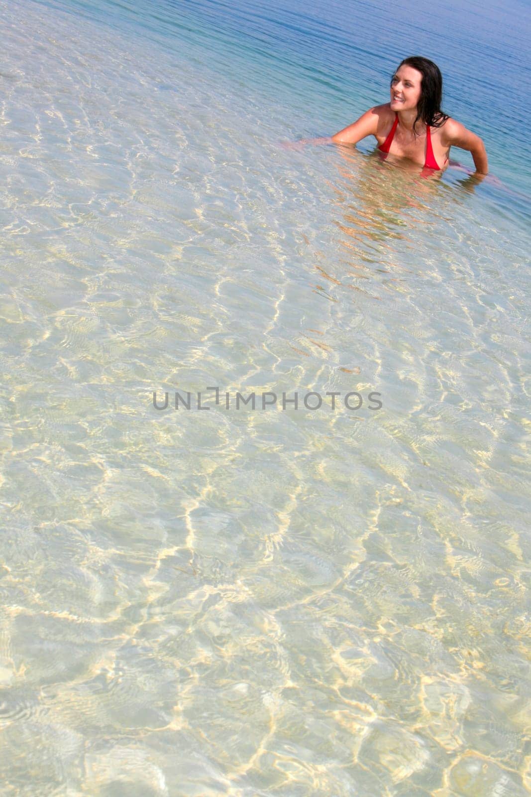 Image of happy pretty woman swimming in a lake