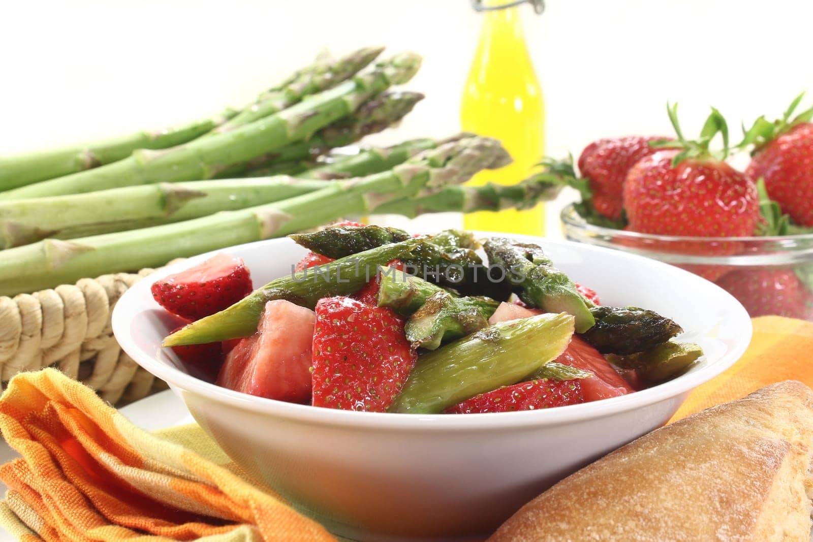 a bowl of asparagus and strawberry salad with fried green asparagus