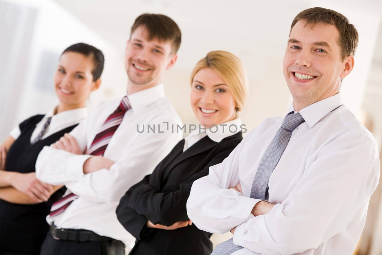 Portrait of happy leader looking at camera in front of his business team
