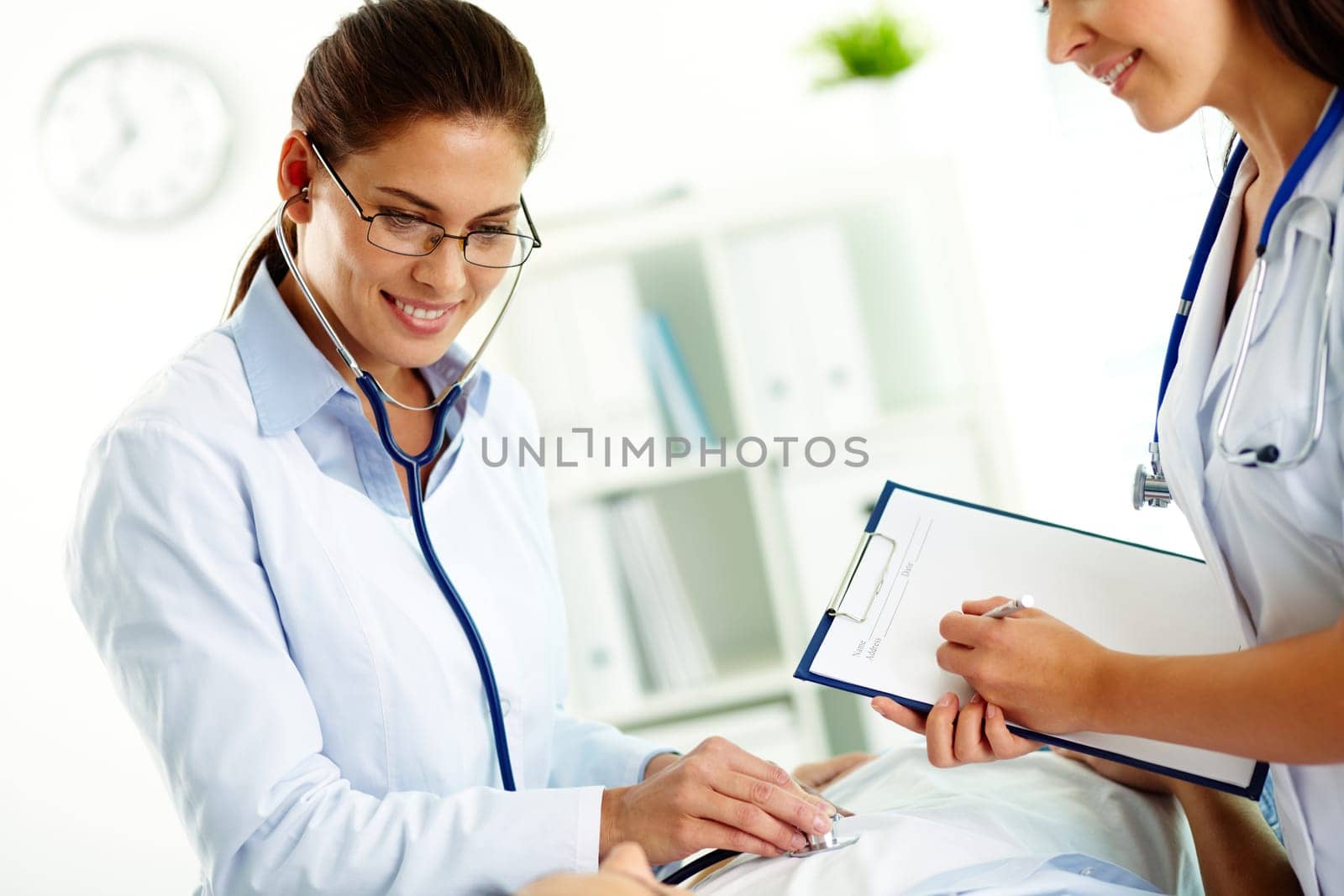Portrait of confident female doctors during medical treatment of patient in hospital