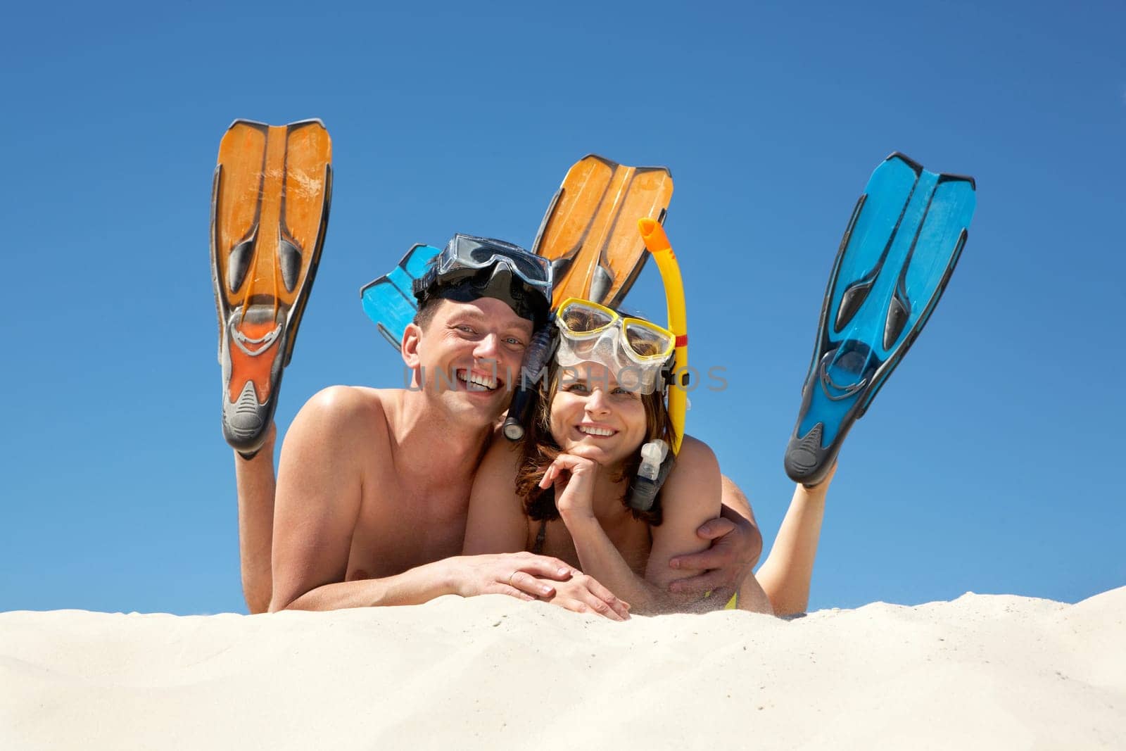 Portrait of cheerful couple in aqualungs looking at camera with smiles