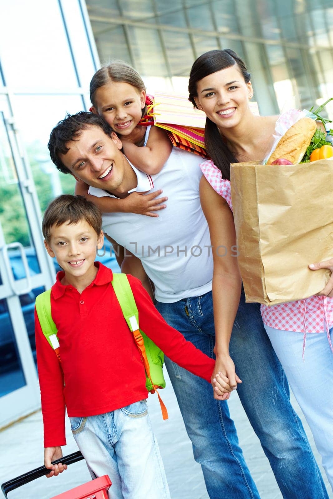 Couple with paperbags and their two children after shopping