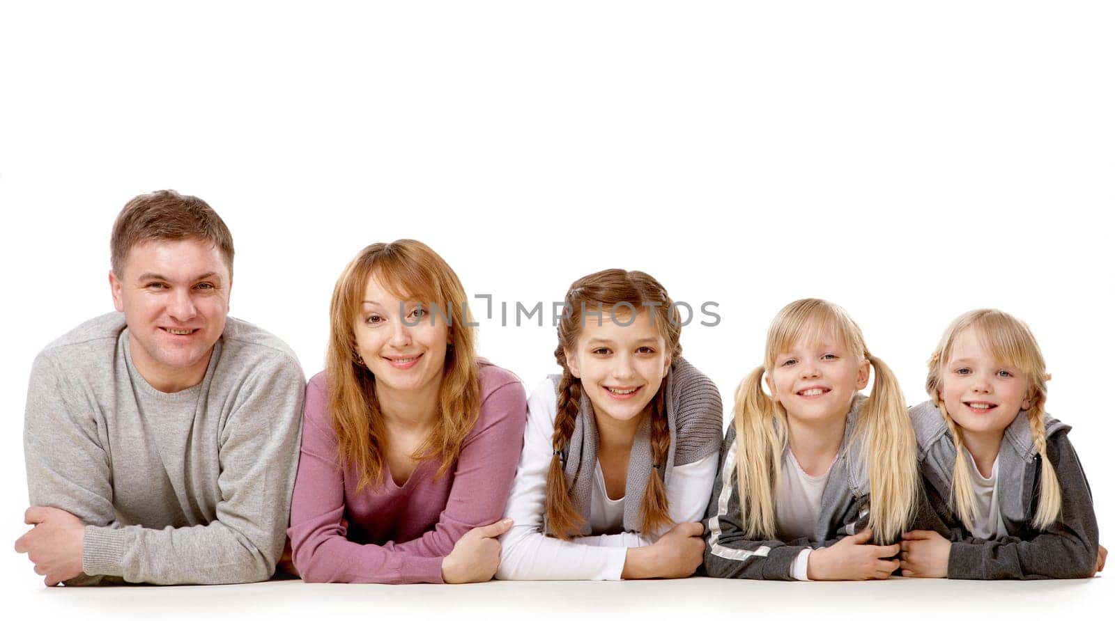 A young friendly family looking at camera on white background
