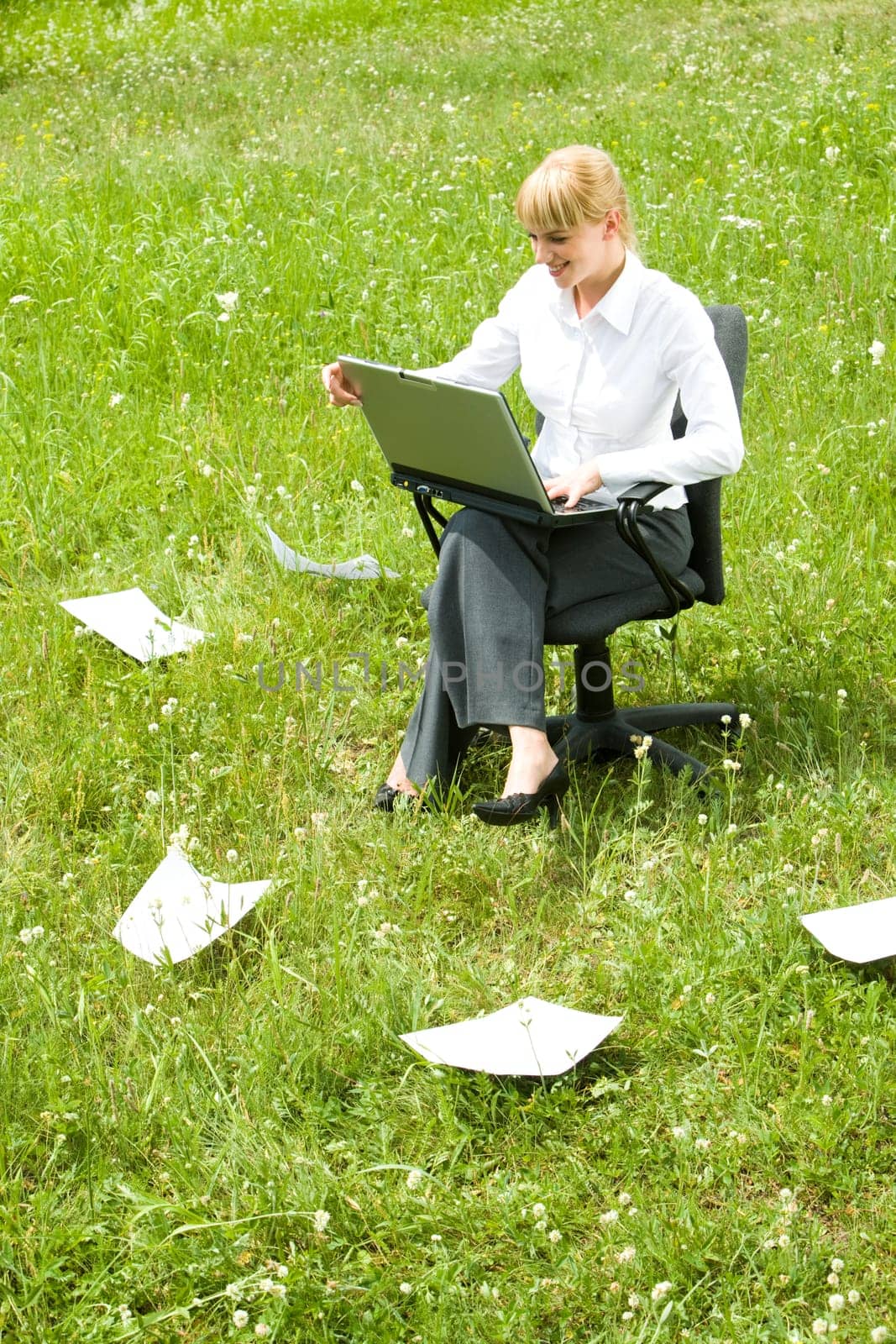 Photo of happy business lady working with laptop outside looking at its monitor