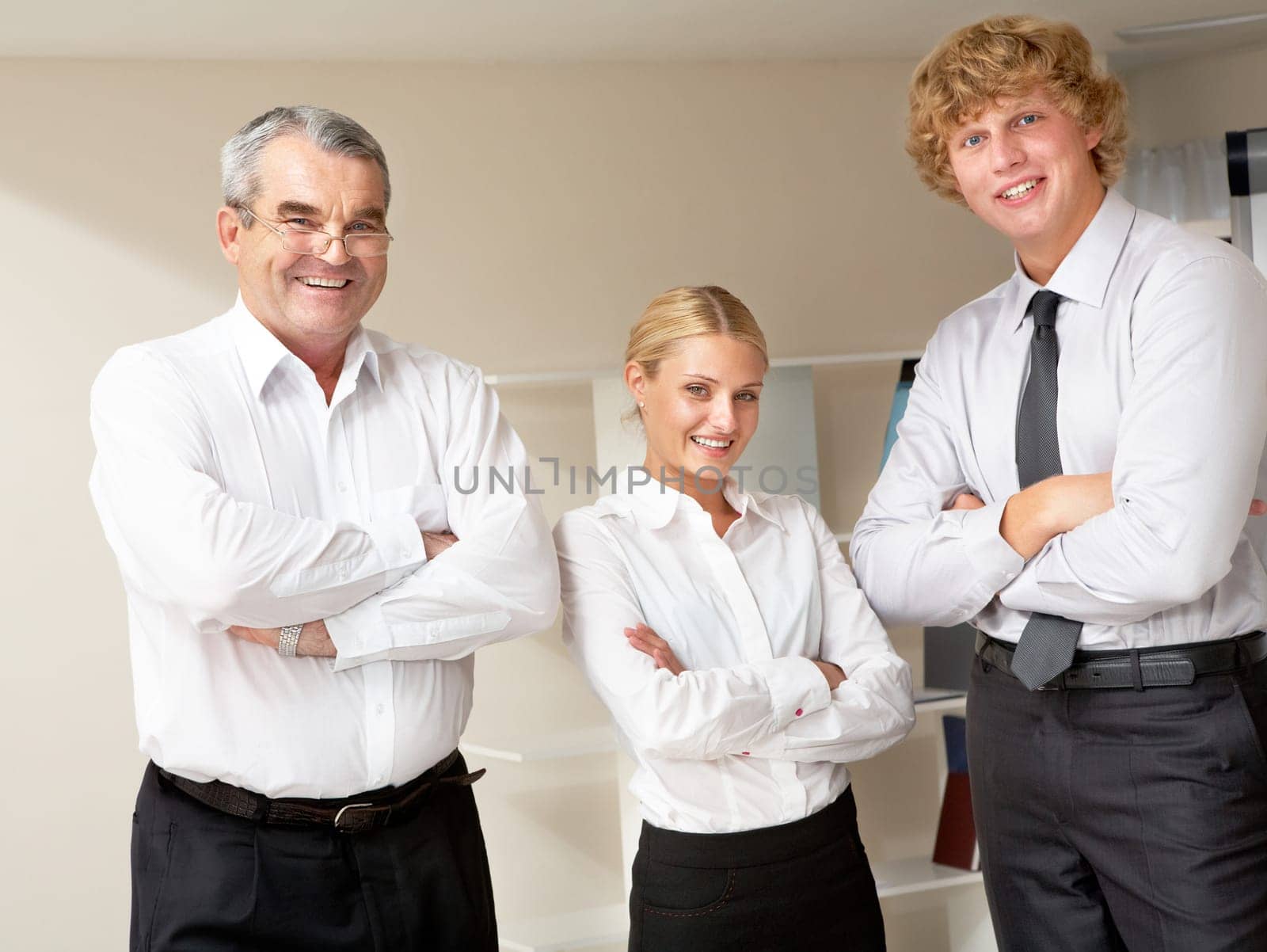 Group of positive three colleagues standing and folding their hands