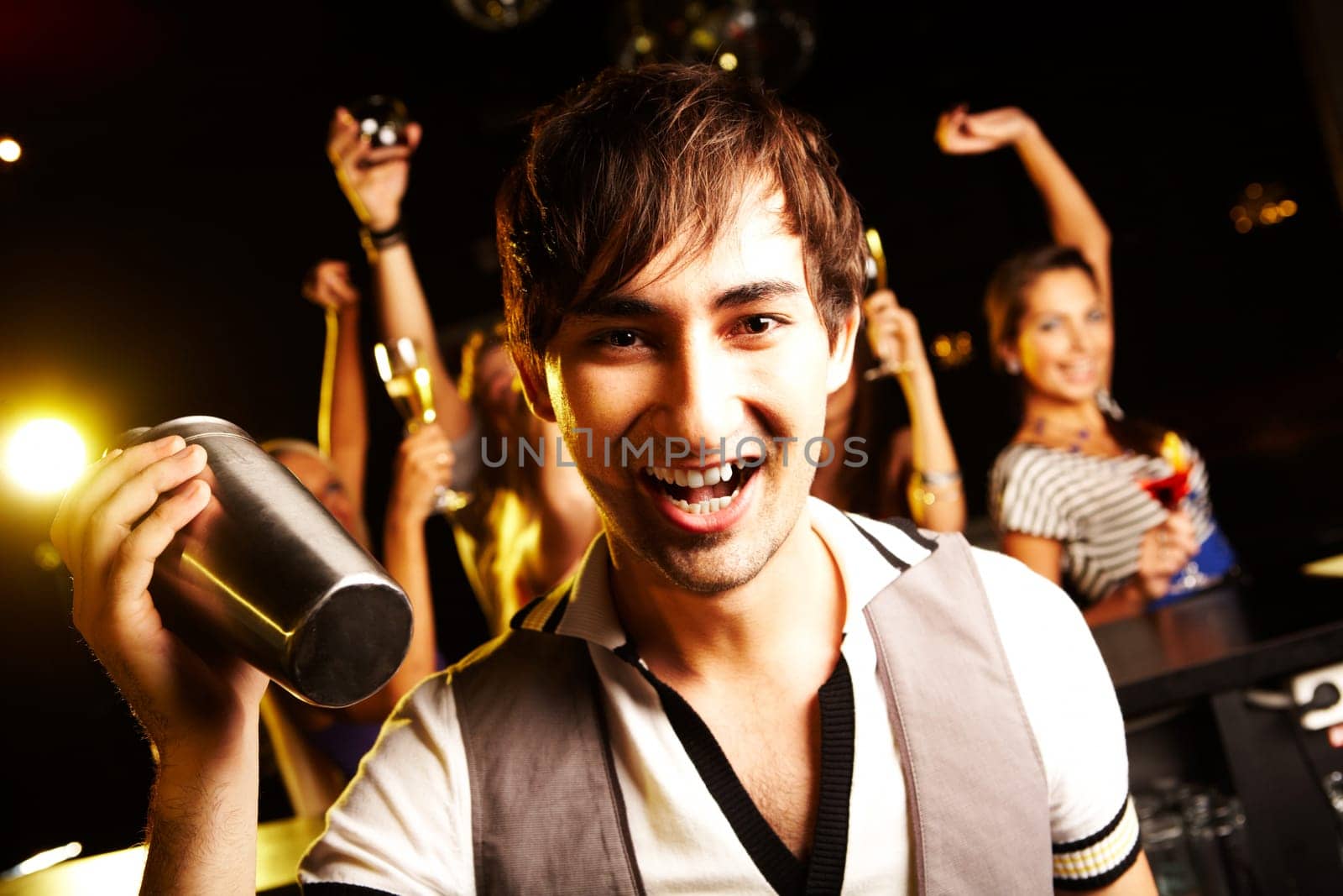 Portrait of smiling male with bottle looking at on background of dancers