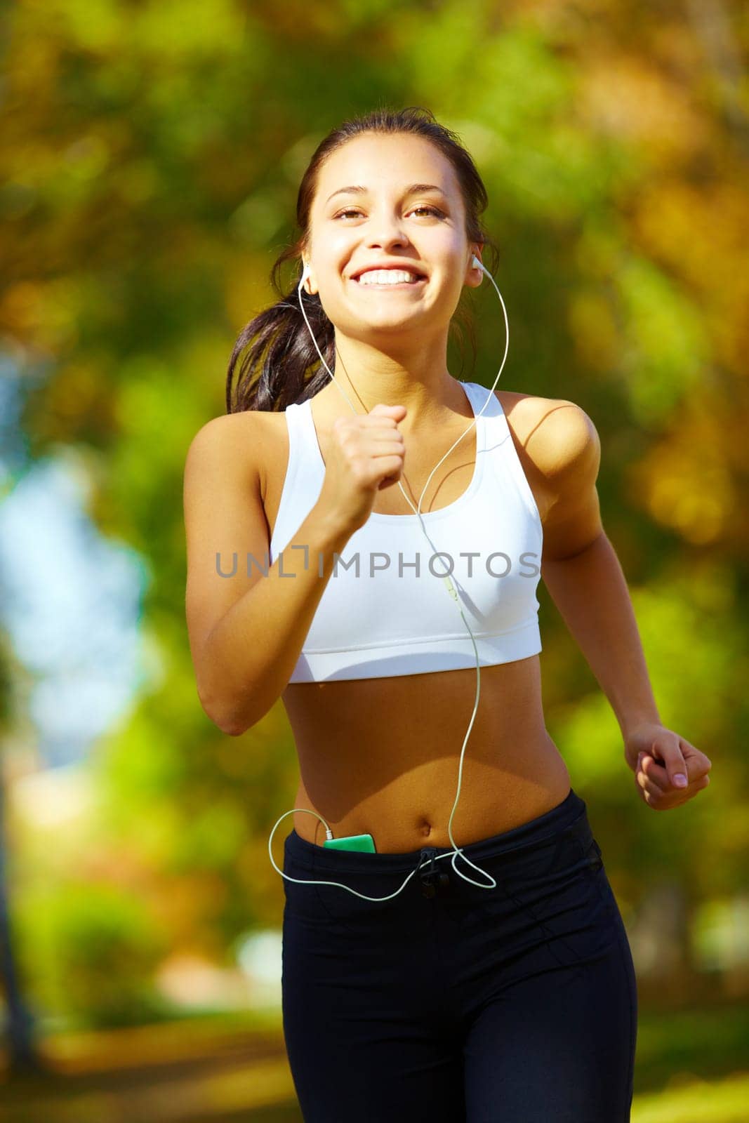portrait of a young woman jogging and listening to the player