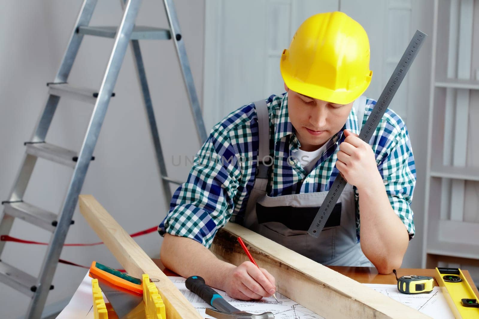 A young repairmen sitting at table and working with a plan