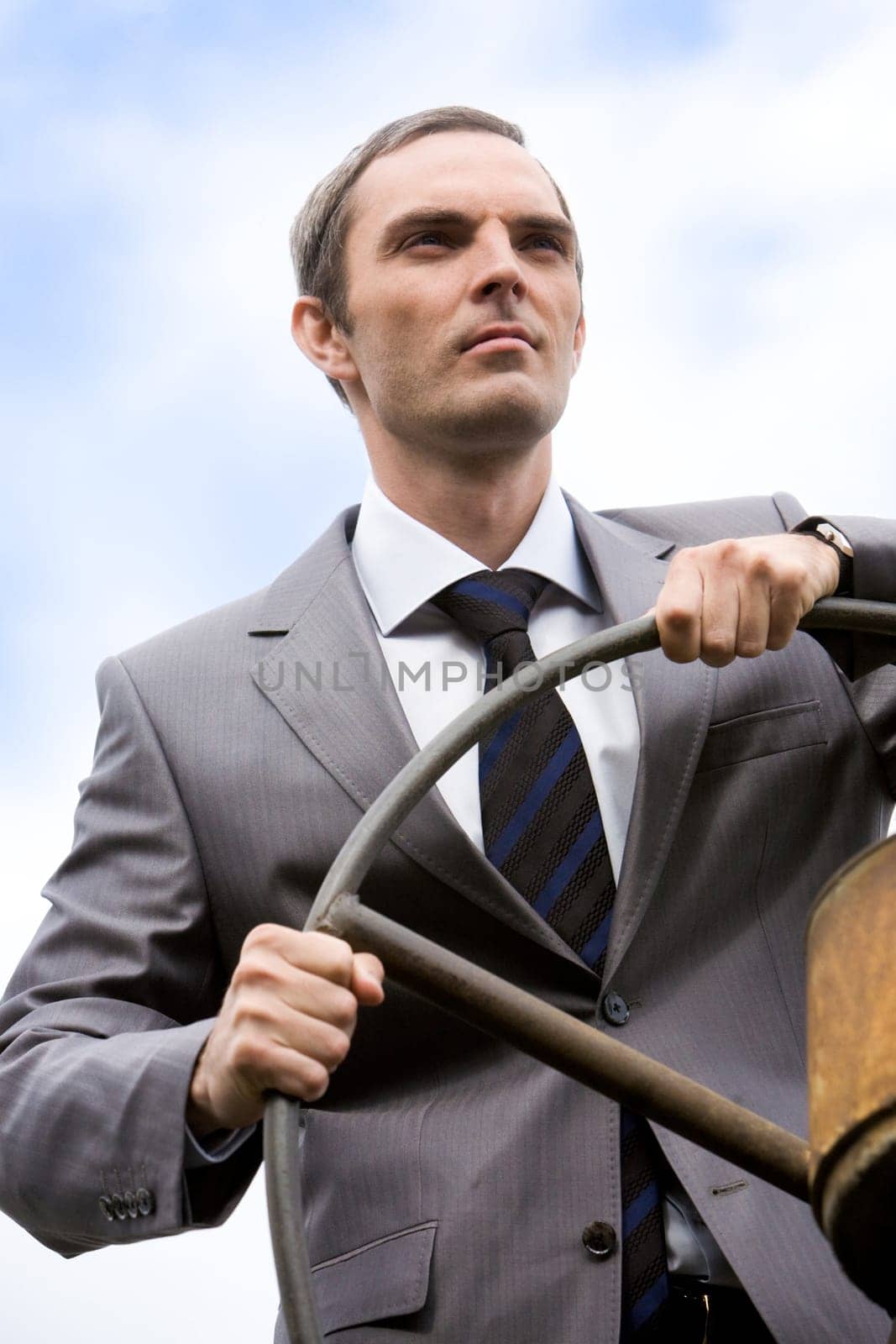 Portrait of powerful businessman holding steer and looking forwards on white background
