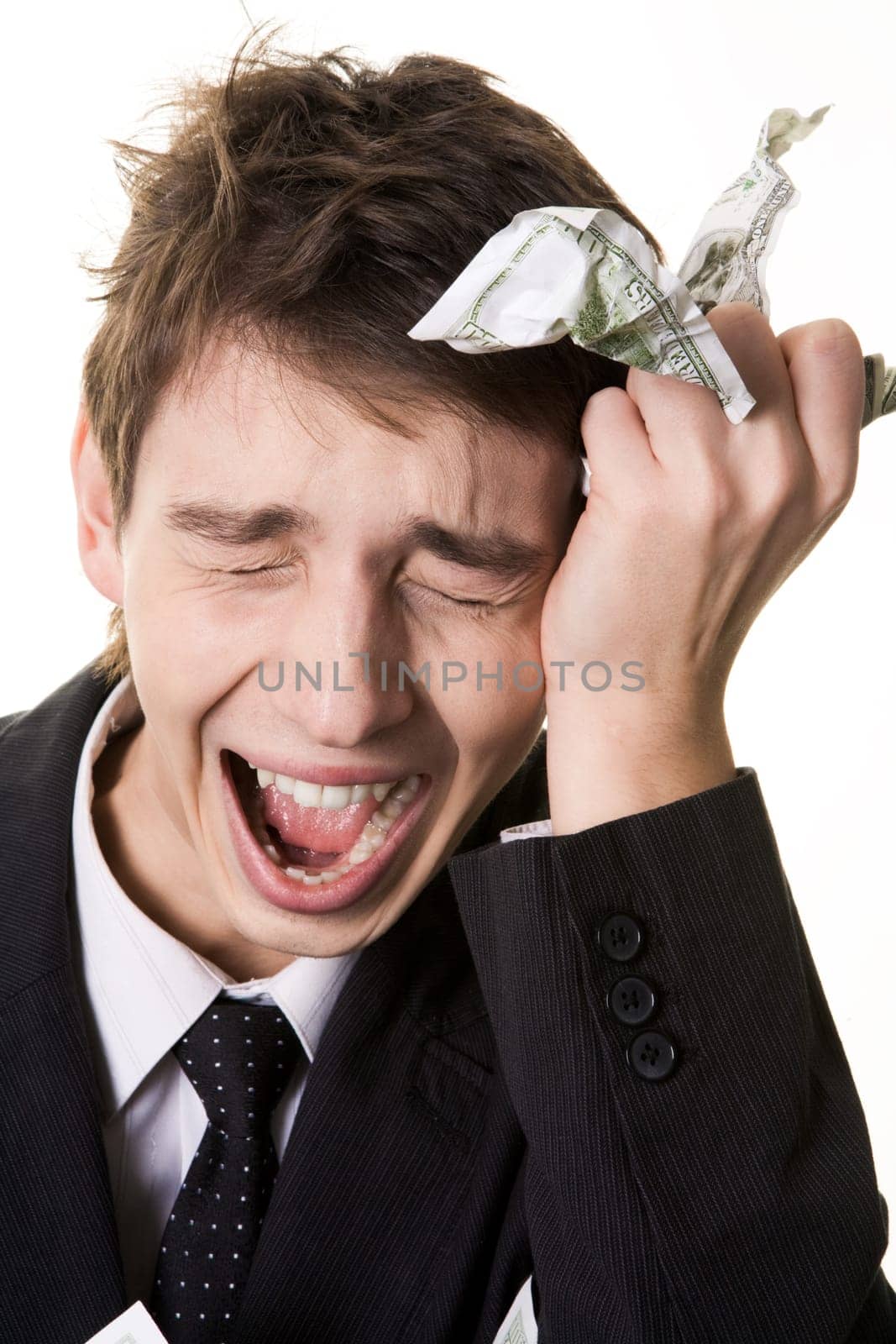 Image of crying businessman touching his head and holding crumpled dollar note in hand