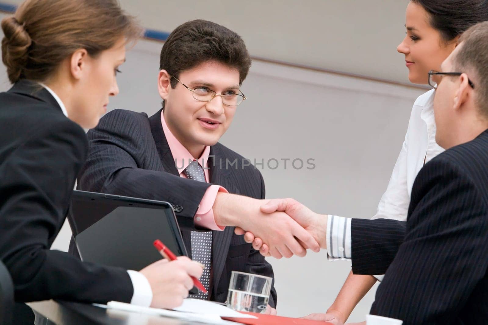 Image of businessmen shaking hands at meeting
