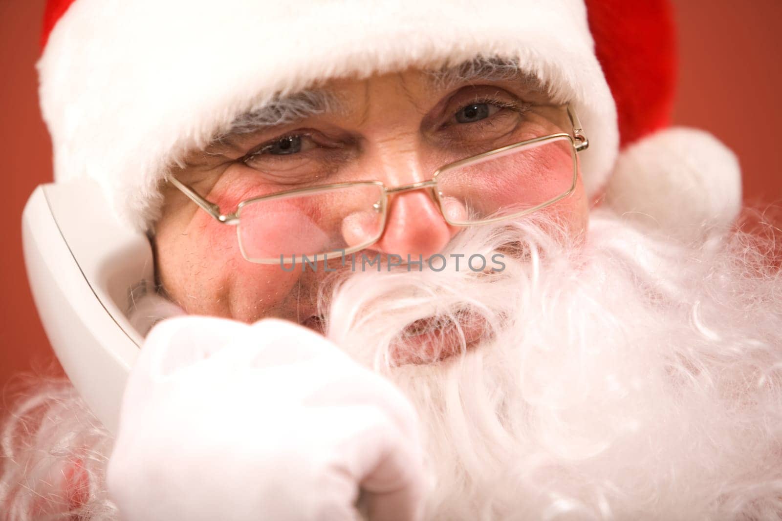 Photo of Santa Claus calling by phone and smiling