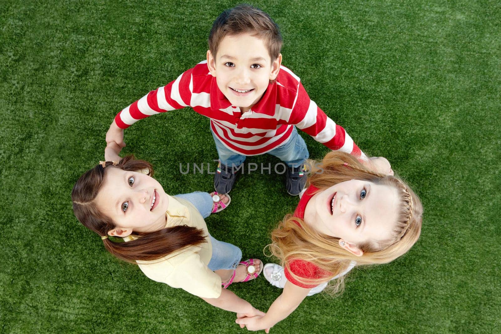 Image of happy friends on the grass looking at camera