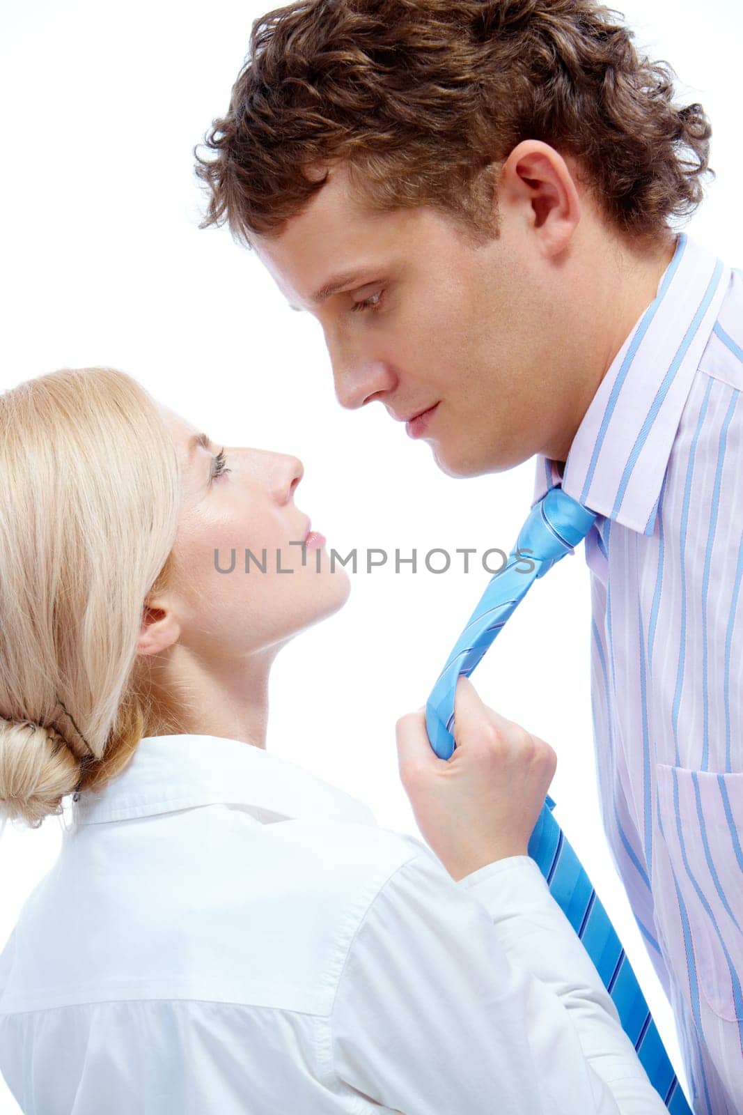 Portrait of female holding mans tie while looking at him
