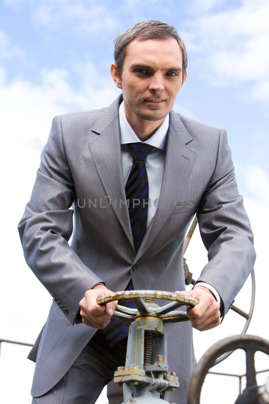 Photo of powerful businessman steering on background of blue sky
