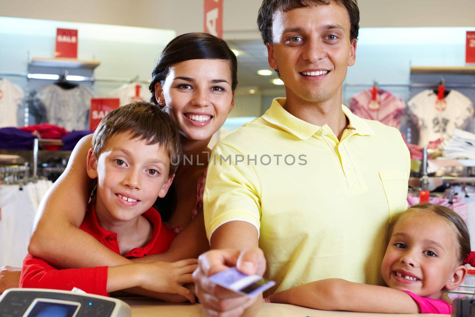 Portrait of family of four giving credit card