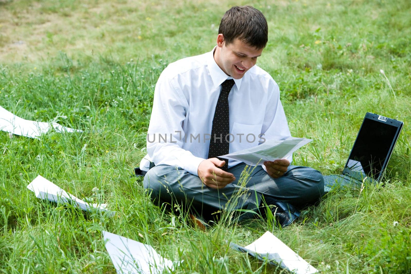 Photo of smiling  businessman holding document and thinking about work