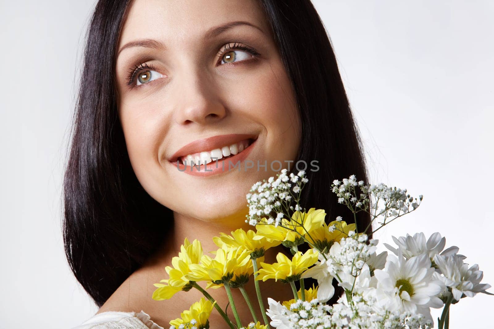 Portrait of pretty girl with bunch of chrysanthemums on grey background
