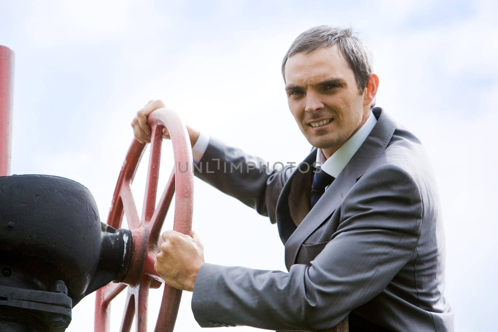 Portrait of confident captain holding rudder and looking at camera with smile