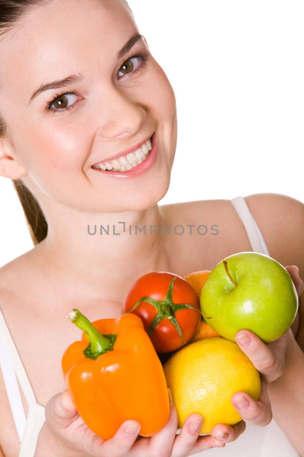 Portrait of pretty girl with different fruits and vegetables in hands smiling at camera
