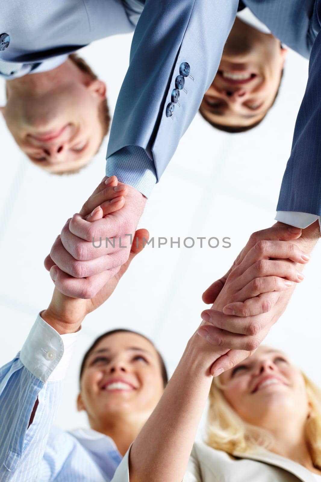 Two pairs of successful associates handshaking after striking deal with partners
