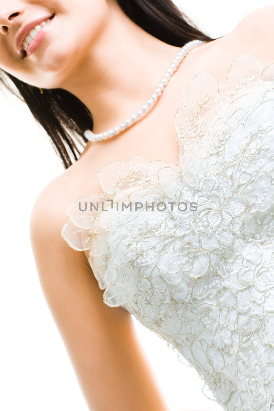 Close-up of beautiful bride in white dress and beads on her neck