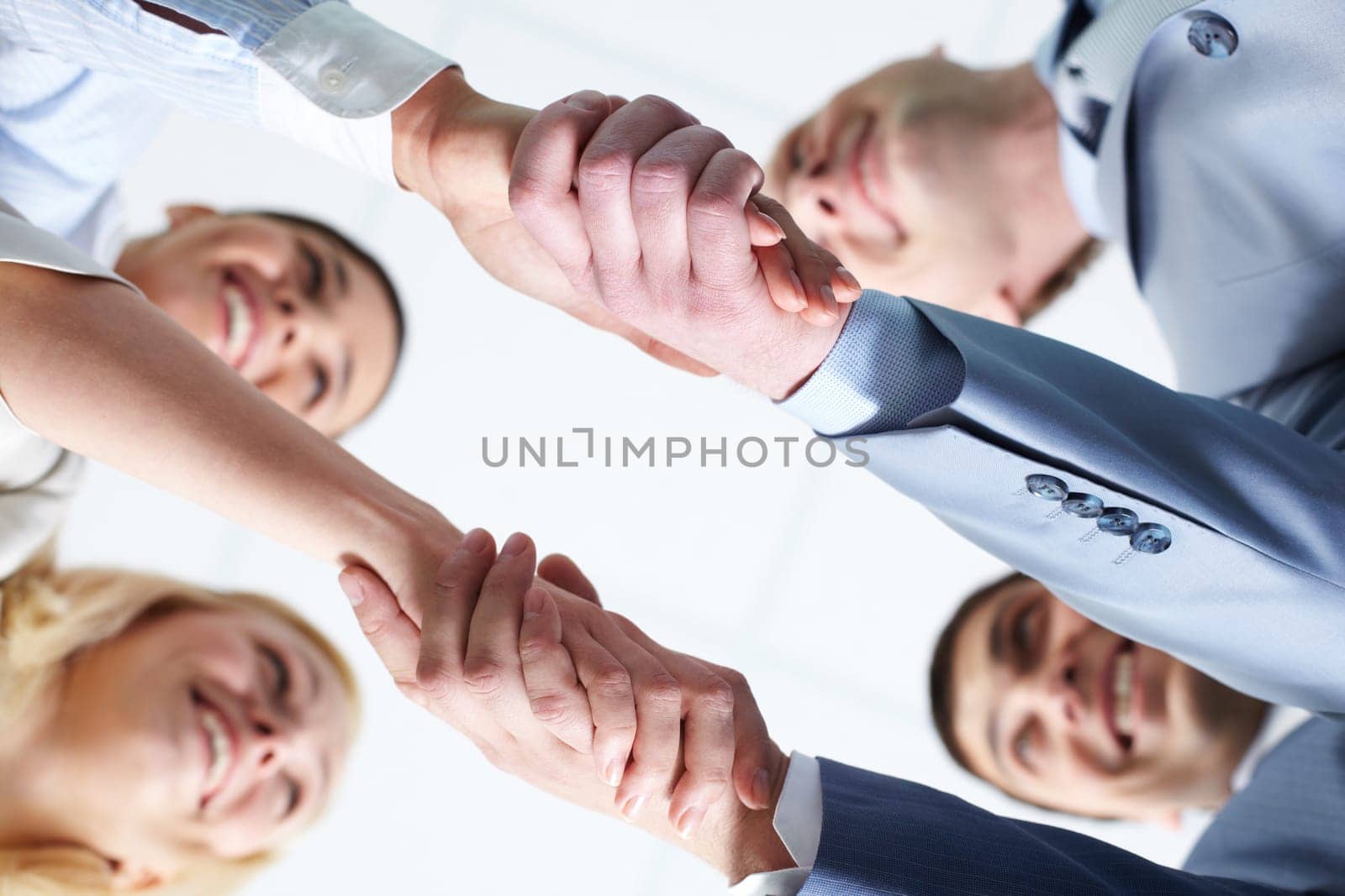 Below view of four people handshaking