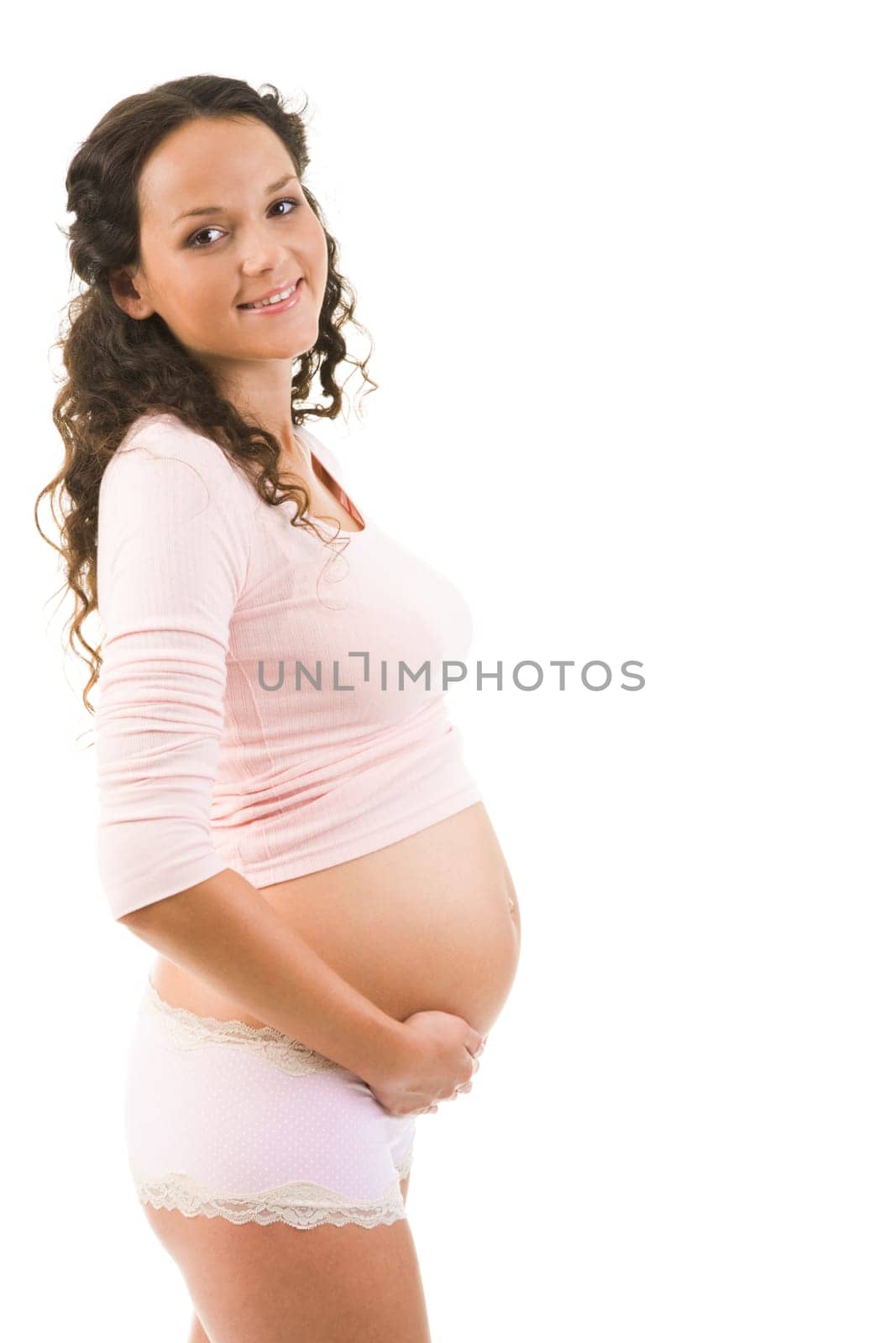 Portrait of pretty pregnant woman wearing tanktop and panties over white background