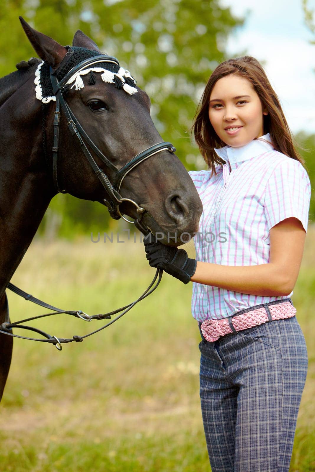 Portrait of smiling female with purebred horse outdoors
