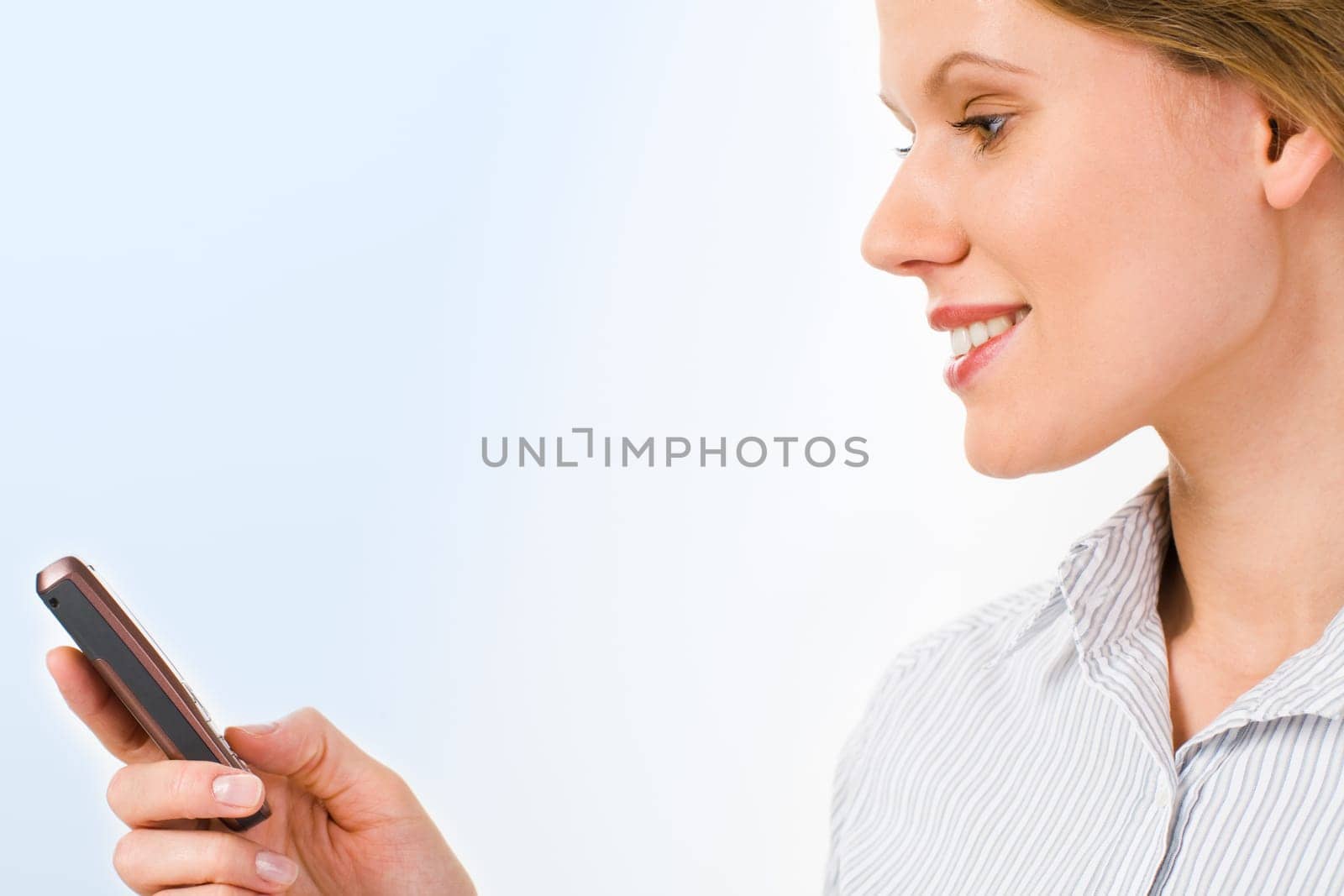 Attractive businesswoman holding her mobile on a blue background